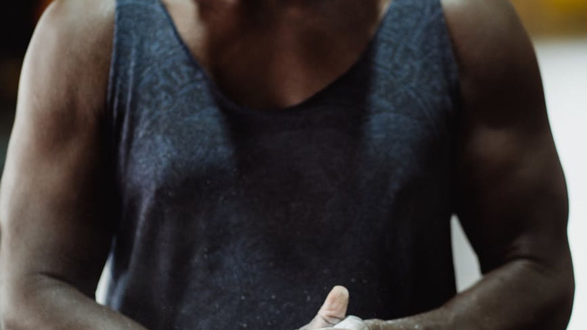 Man in a focused state preparing for a workout in a minimalist gym.