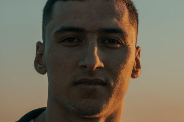 Silhouette of a man stretching against a sunrise, symbolizing the start of a process.